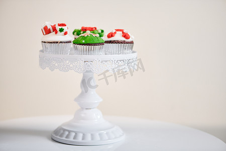 可爱的圣诞元素摄影照片_自制圣诞纸杯蛋糕，配有传统红绿色装饰符号元素