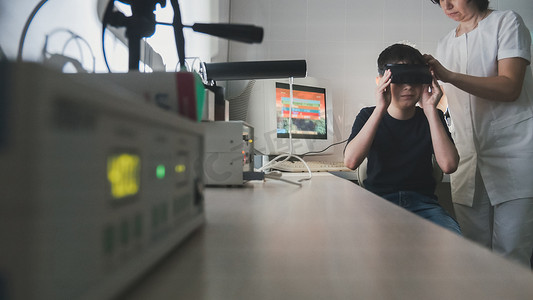 立体医学摄影照片_眼科医生借助立体视频虚拟现实眼镜检查孩子的视力