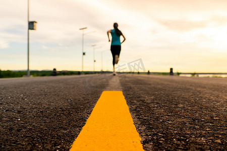 运动员在马拉松和健身的日落训练中在公路上奔跑。