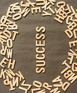 木制立方体字母表字母中的成功词在仿古纸背景上的顶部视图。