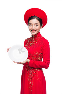 穿着传统 Ao Dai 的越南女人微笑，并在白色背景下介绍产品。