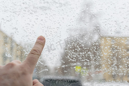 悲哀地摄影照片_男人的手指触摸冰冷的汽车玻璃