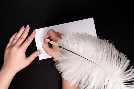 女手用带复制空间的羽毛笔在白纸上书写