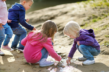 溪流玩耍摄影照片_四个快乐的孩子在河边玩耍