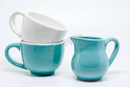 陶器摄影照片_白色背景上的两个陶瓷杯和水罐