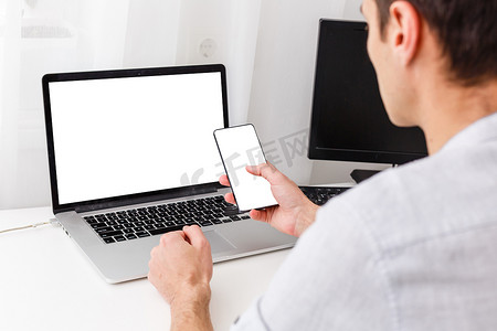 在互联网上工作的现代商人坐在前面打开笔记本电脑的背面视图，上面有空白的空屏幕供您查看信息或内容