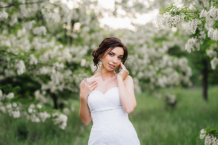 新娘穿着白色的裙子，拿着一大束春天的花束