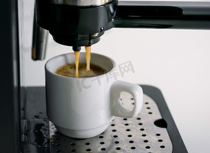 萃取咖啡摄影照片_咖啡机萃取到咖啡杯中