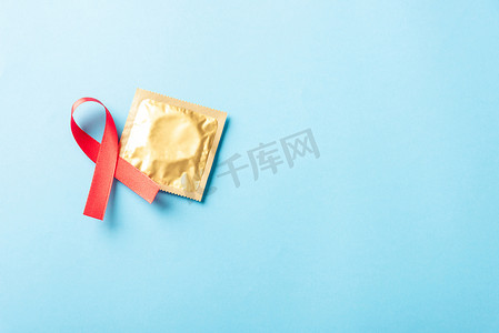 蝴蝶结丝带摄影照片_红色蝴蝶结丝带象征艾滋病毒、艾滋病癌症意识和避孕套