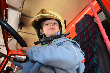 孩子消防员摄影照片_小男孩像消防员。