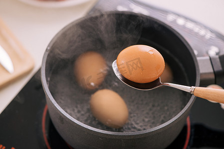 汁水摄影照片_厨师将煮鸡蛋放入杯中/烹饪甜棕色炖猪肉肉汁 (Moo Pa-lo) 概念