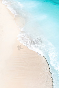 热带海滩，鸟瞰海浪拍打热带金色沙滩的情景。