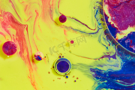 漂浮的细菌摄影照片_带有小漂浮球体的彩色黄色、蓝色和红色液体表面