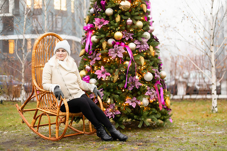 时尚专区摄影照片_女人和照片区街上的圣诞树和摇椅