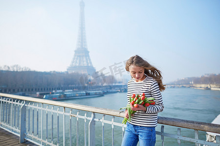 埃菲尔铁塔附近拿着一束红色郁金香的女孩