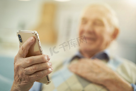 在家使用手机的微笑的老人