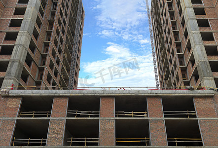 基础建设详情页摄影照片_蓝天白云映衬下一座正在建设的新房子的两部分