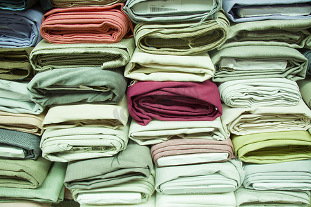 卷轴背景摄影照片_在商店货架上制作丝绸和布料，在市场上轧制丝绸，多色和多种图案纹理背景。