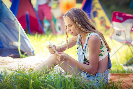 手机夏季夏季摄影照片_在露营地使用手机的妇女