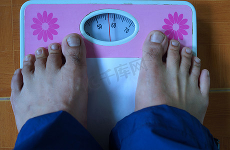 脚踩体重秤、健康和体重管理概念。
