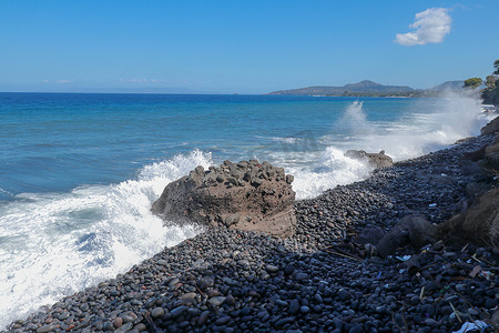 海浪拍打着石滩，形成了巨大的浪花。