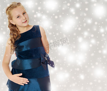 美丽的小女孩穿着一件蓝色的裙子。