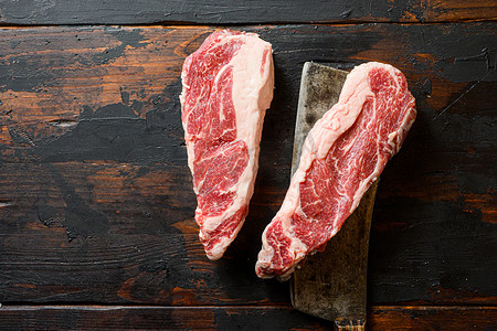 大理石纹摄影照片_Raw Chuck Tenders 大理石纹黑安格斯牛肉放在切肉刀上。