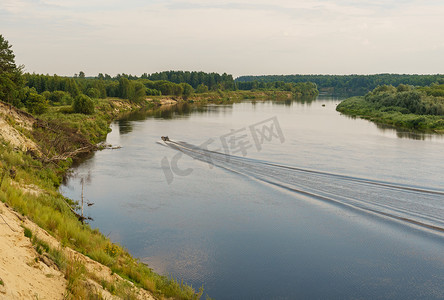 河岸摄影照片_河岸和一艘摩托艇在水面上行驶