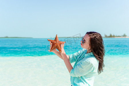 海滩上有海星的可爱女孩