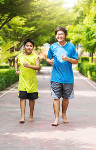 亚洲兄弟俩在公园里一起跑步。