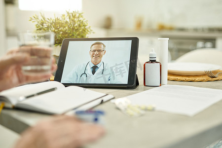 友好的家庭医生在视频通话中出现在平板电脑屏幕上