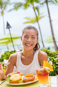 幸福的女人在餐厅吃夏威夷汉堡配菠萝和炸鸡。