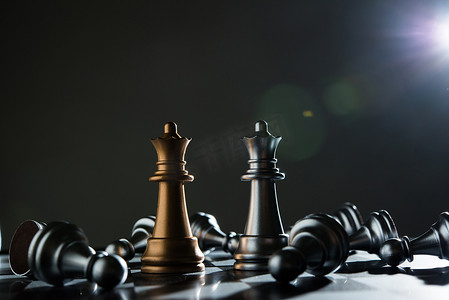 红色的国际象棋摄影照片_深色背景下的国际象棋国王和骑士。