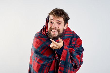 饮料冒气摄影照片_冷男人用毯子暖饮料健康问题