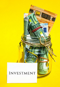 文字注释摄影照片_欧元货币用橡皮筋兑现，注释文字写为投资，财富创造者心态的概念，提醒自己设置少量资金进行投资