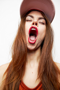 戴帽子的女人张大嘴巴，带着有趣的情绪闭上眼睛橙色裙子