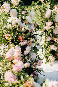 在绿色草坪上的街道上举行的婚礼。婚礼用鲜花拱门装饰