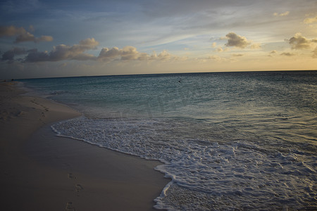 日落真实摄影照片_阿鲁巴岛白色海滩上美丽的金色日落和碧绿的海水 — 加勒比日落 — 真实的色彩，没有滤镜