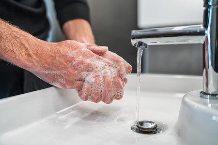 冠状病毒旅行预防男子展示手部卫生用热水肥皂洗手以保护冠状病毒细菌传播