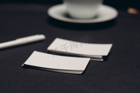 公司财务模板摄影照片_黑色桌子上的名片和办公室工作财务中的一杯咖啡