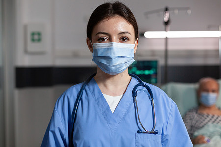 护士戴口罩摄影照片_在病房里戴手术面罩的医生保健专家