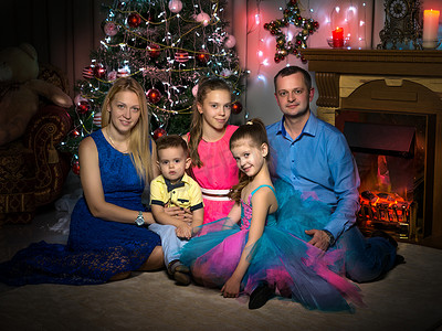 有孩子的家摄影照片_有孩子的幸福大家庭在圣诞树附近。
