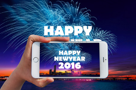 手拿着智能手机拍照在新年快乐 2016 年和