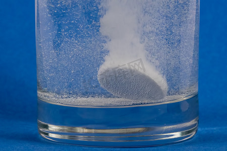 消毒泡腾片摄影照片_溶解在一杯水中的泡腾片