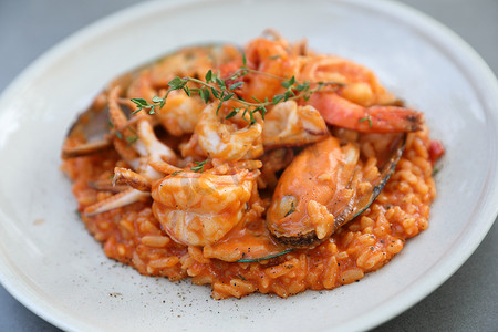 烩海鲜摄影照片_海鲜烩饭配贻贝虾和鱿鱼，意大利食品