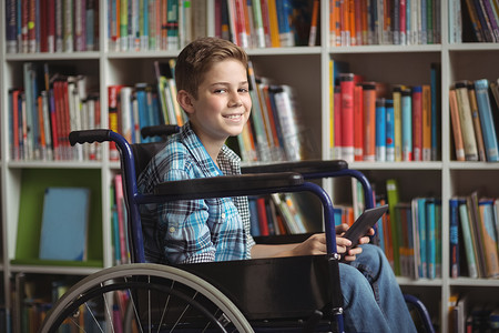 图书馆里拿着数字平板电脑的残疾男学生肖像