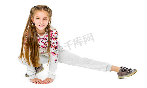 可爱芭蕾摄影照片_可爱的小女孩做伸展运动孤立在白色背景上