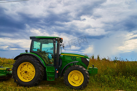 有风雨如磐的云彩的农用拖拉机设备约翰鹿