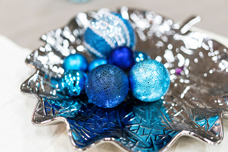 银盘上闪亮的蓝色圣诞装饰品。