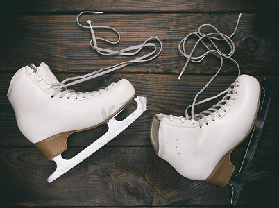 花样鞋带摄影照片_老式白色女式花样滑冰鞋，未绑鞋带